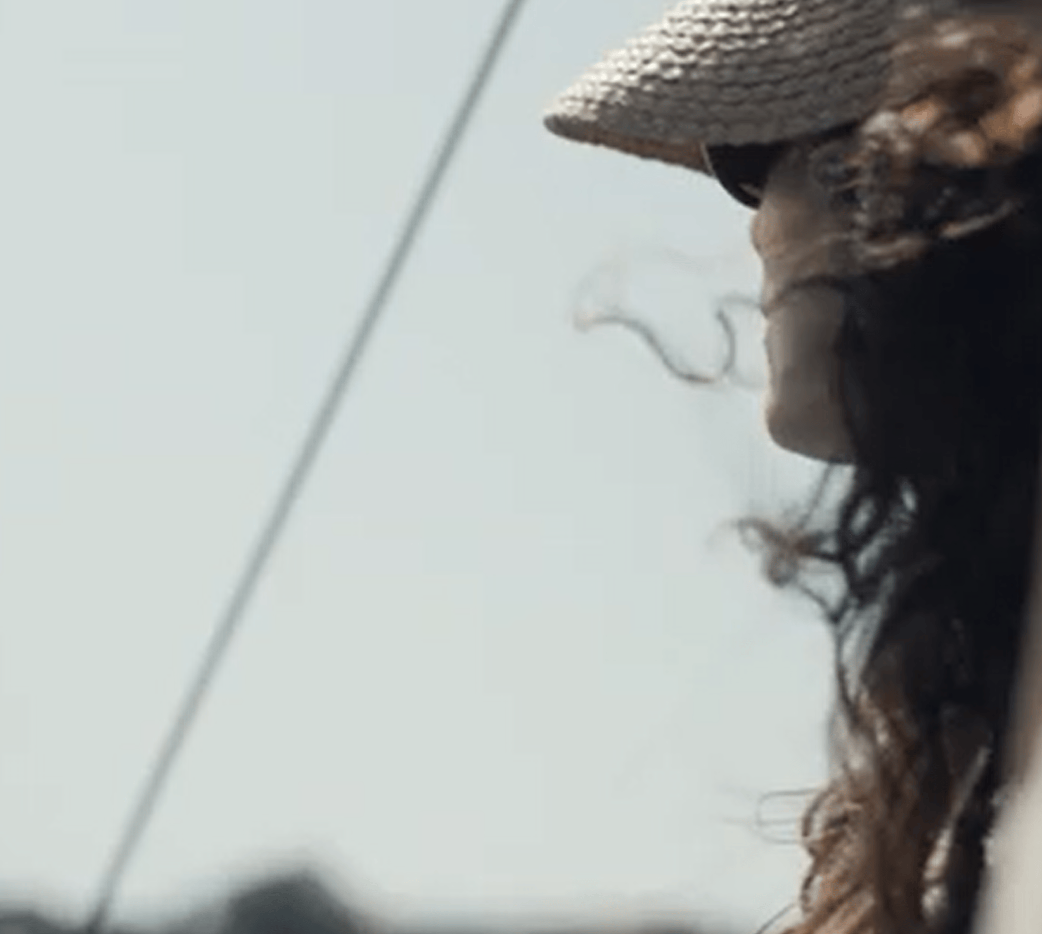 Woman wearing a hat looking out at the sky